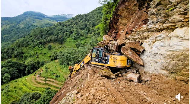 सडक खन्दै गरेको डोजर माथि ढुंगाको पहिरो
